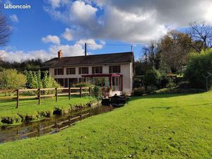Ancien moulin dans un écrin de verdure avec plan d'eau