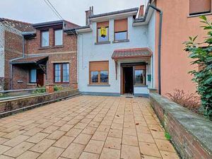 Maison mitoyenne avec garage et jardin.