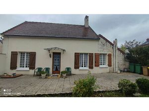 Maison de plain pied avec un terrain et deux garages.