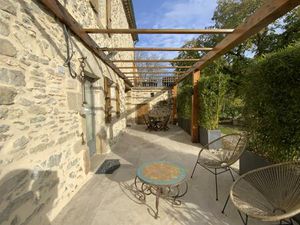 Maison en pierre rénovée avec jardin arboré.