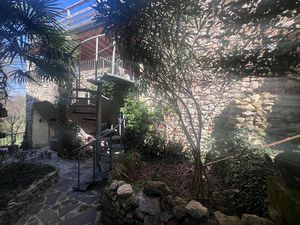 Maison en pierres avec terrasses et cour intérieure.