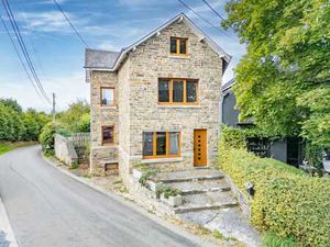 Vaste bâtisse en pierre avec garages et jardin