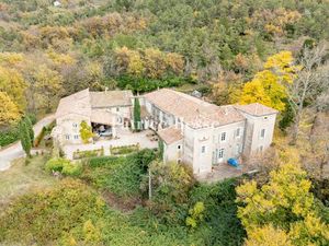 Adossé à une colline boisée  avec vue panoramique sur les monts d'Ardèche  un château du..