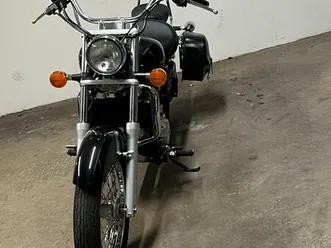 schwarzes motorrad cruiser mit windschild und taschen